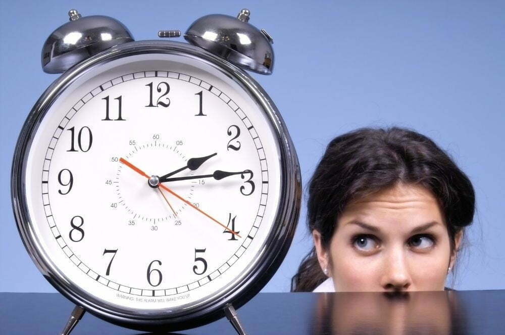 What's the "right length" for online learning activities and lessons? Young brunette looking at large alarm clock.