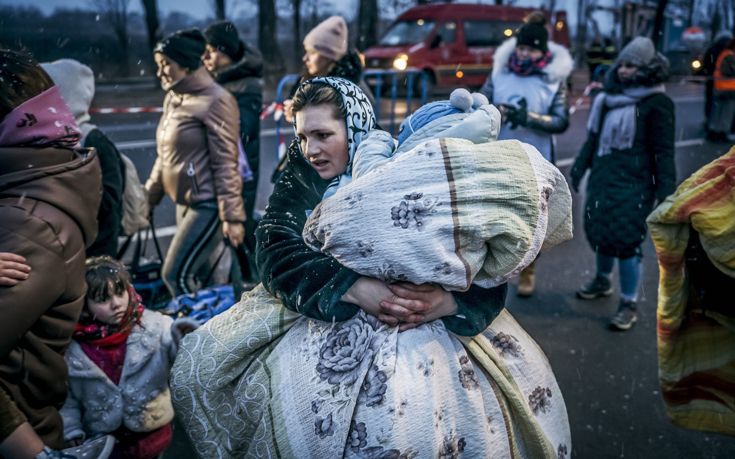France hits out at UKs overly restrictive approach to Ukrainian refugees: A Ukrainian woman carries a child in a blanket after crossing the border in Siret, Romania. About 660,000 people have fled Ukraine to neighbouring countries in the past six days