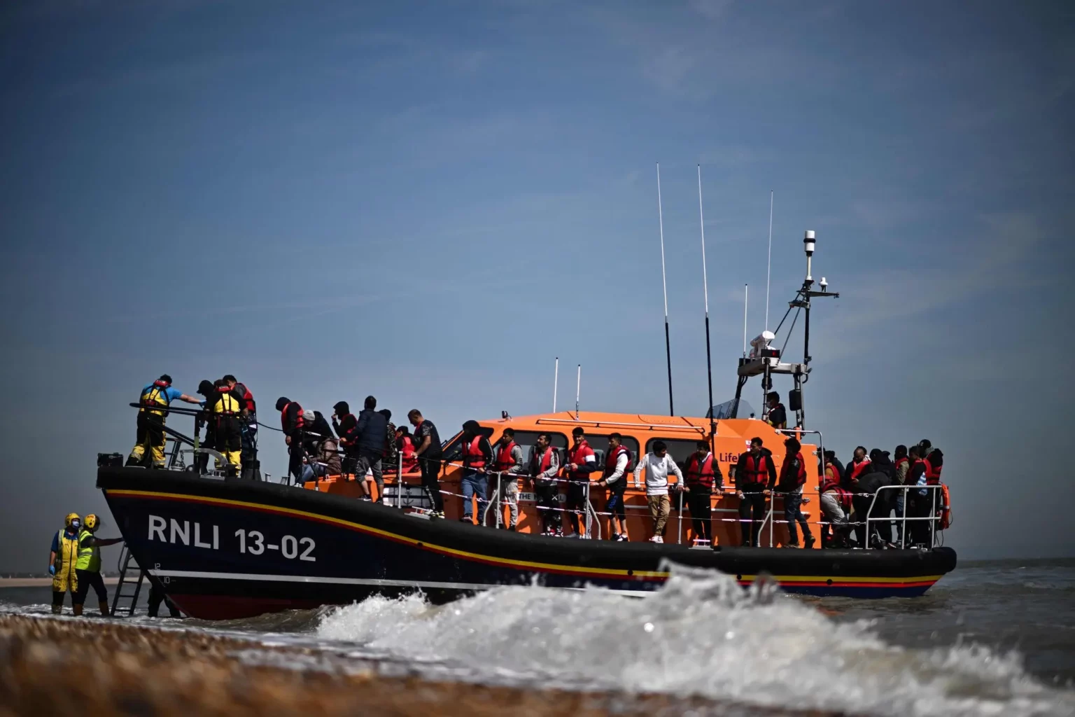Migrants, picked up at sea after attempting to cross the English Channel in June, were brought ashore by the Royal National Lifeboat Institution on the southeast coast of England.Credit...Ben Stansall/Agence France-Presse — Getty Images