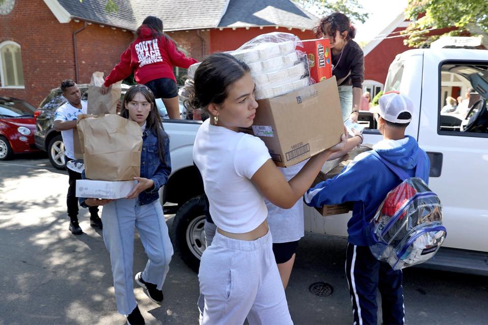 Martha's Vineyard, MA - September 15: Students from the Marthas Vineyard Regional High School AP Spanish class help deliver food to St Andrews Episcopal Church. Two planes of migrants from Venezuela arrived suddenly Wednesday night on Martha's Vineyard. The students served as translators for the migrants.