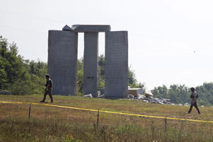 Image: Law enforcement officials walk around the damaged Georgia Guidestones monument near Elberton, Ga., on July 6, 2022. (Rose Scoggins / The Elberton Star via AP)