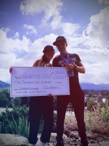 photo of two people holding a giant check for Guardian Group from the Ironman Foundation