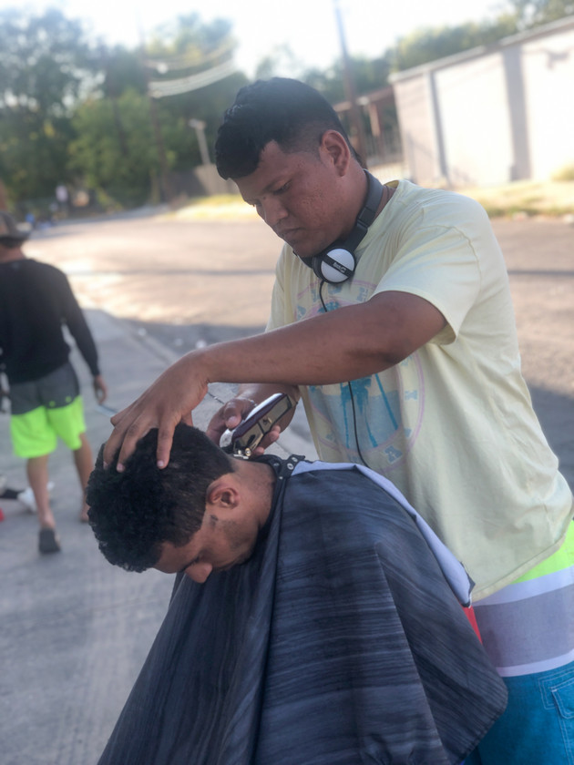 Alexis Bracho gives a haircut near the Migrant Resource Center.
