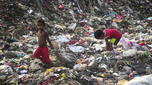 Two children in Bangladesh look for objects in the garbage in Bangladesh