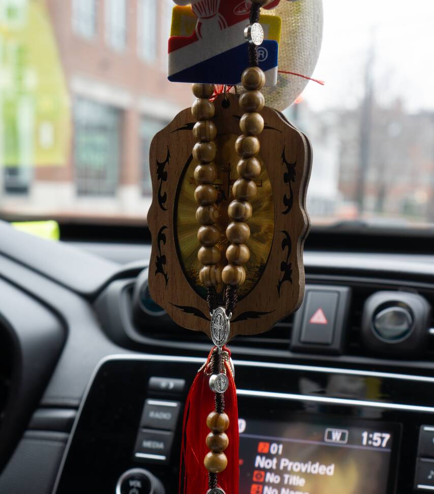 2023Billy-4.jpg A set of rosary beads and a depiction of Christ on the cross hang on Billy's car's rear-view mirror. 