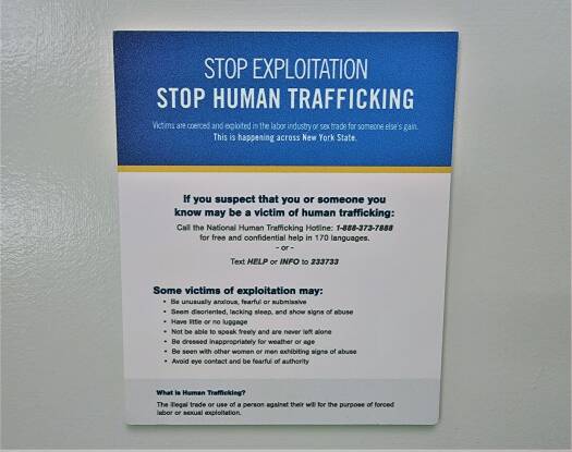A sign posted to a wall says "Stop exploitation. Stop human trafficking"